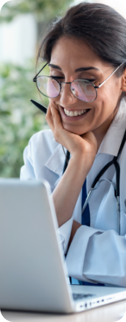 Smiling woman in lab coat using laptop in laboratory.